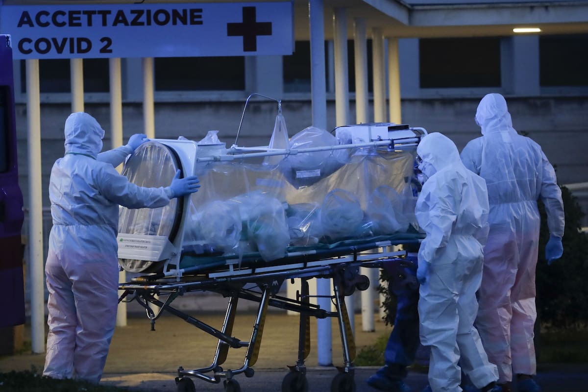 Los trabajadores sanitarios trasladan a un paciente afectado por coronavirus en Roma