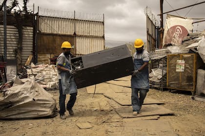 Los trabajadores se aseguran de que los gases utilizados en los aparatos viejos se eliminen de forma segura