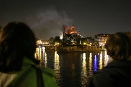 Los transeúntes observan el incendio de la catedral de Notre Dame, hoy en París