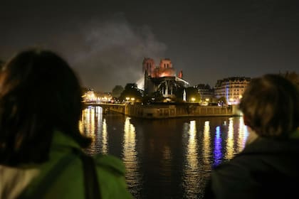 Los transeúntes observan el incendio de la catedral de Notre Dame, hoy en París