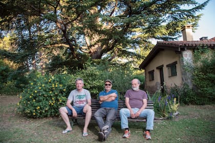 LOS TRES Andrea Prodan, Germán Daffunchio y Timmy McKern, hoy, en el paisaje inspirador donde todo comenzó. Abajo, Andrea en su garaje