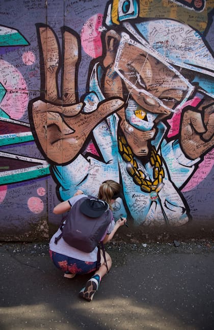 Los turistas firman el "muro de la paz".
