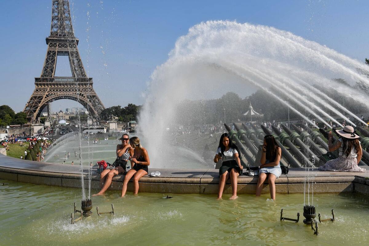 Los turistas se refrescaban en la plaza Trocadero, ayer, en el centro de París