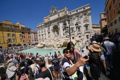 Los turistas se toman una selfie frente a la Fontana de Trevi, en Roma, el lunes 20 de junio de 2022