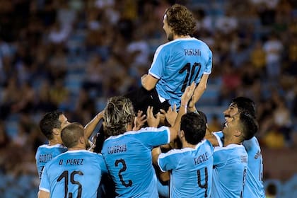 Los uruguayos alzan a Forlán durante el amistoso