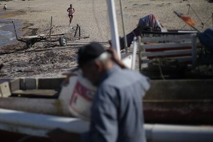 Los vecinos de José Ignacio cruzan por el pequeño puerto mientras los pescadores llegan tras ocho horas en el mar