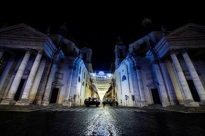 Los vehículos militares patrullan en la Piazza del Popolo en el centro de Roma el 31 de diciembre de 2020, durante la víspera de Año Nuevo, ya que se implementa el toque de queda de 22 a 7 en Italia para frenar los contagios
