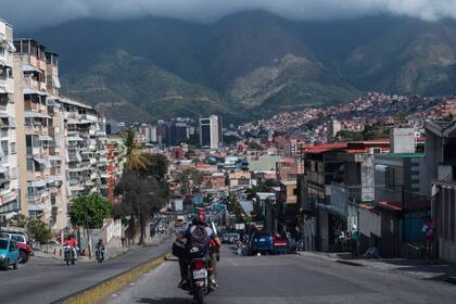 Los venezolanos andan en motocicleta en una calle del popular barrio de Petare en el marco de la semana flexible que forma parte del programa establecido por el gobierno para prevenir la propagación del coronavirus en Caracas el 11 de enero de 2021