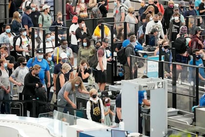 Los viajeros pasan por el punto de control de seguridad en el Aeropuerto Internacional de Denver el viernes 2 de julio de 2021 (David Zalubowski/AP)