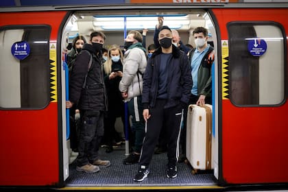 Los viajeros que usan barbijo para combatir la propagación del coronavirus, en un subte de Londres