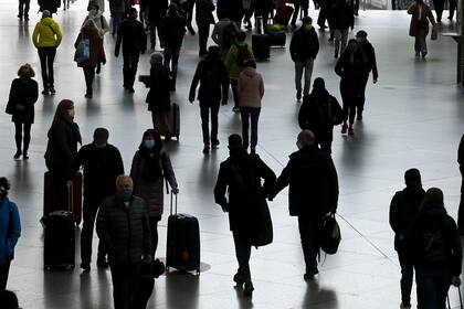 Los viajeros usan máscaras protectoras mientras caminan por un pasillo de la estación principal de trenes en Múnich, en el sur de Alemania, el 13 de octubre de 2020, en medio de la pandemia del nuevo coronavirus