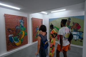 Los visitantes observan las pinturas del artista brasileño Maxwell Alexandre en la galería fundada por el artista, en la favela Rocinha de Río de Janeiro, Brasil