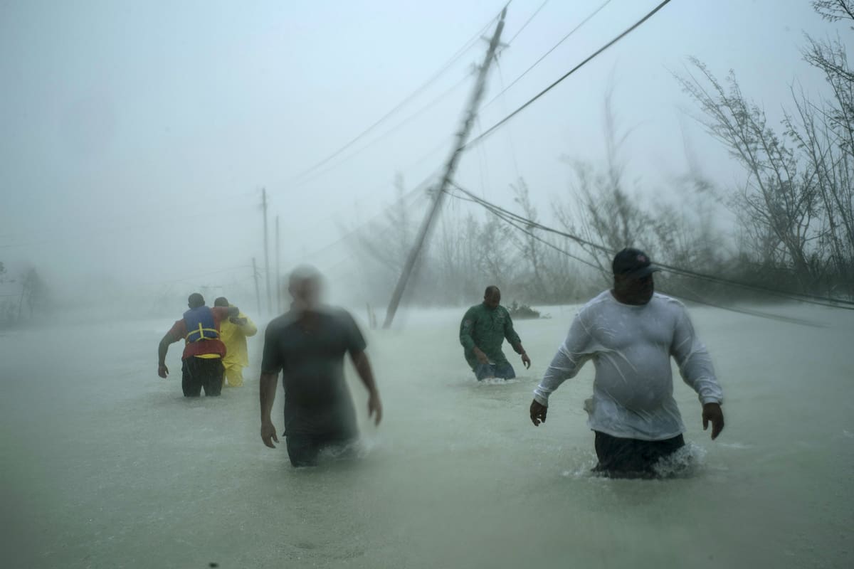 Los voluntarios parten en un bote a motor para rescatar a las personas atrapadas por las crecientes aguas del huracán Dorian, en una carretera inundada cerca del puente Causarina en Freeport, Gran Bahama