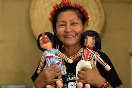 Luakam Anambé posa con unas muñecas indígenas en su taller de Río de Janeiro, el martes 24 de mayo de 2022. (AP Foto/Silvia Izquierdo)