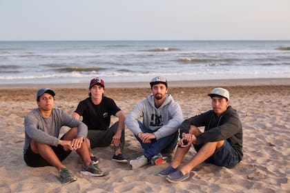 Lucas, José, Pablo y Facundo, los hijos de Ramón Román, se sientan en la playa poco después de ser informados de que Prefectura dejará de buscar a su padre con vida