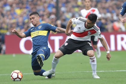 Lucas Olaza disputa la pelota con "Pity" Martínez en el partido de ida de la final de la Copa Libertadores 2018