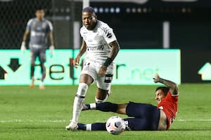 Lucas Rodriguez intenta frenar un avance de Marinho, el más peligroso de Santos, (Photo by CARLA CARNIEL / POOL / AFP)