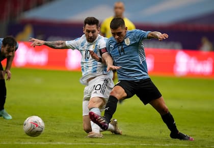 Lucas Torreira lucha por la pelota con Lionel Messi, en un partido entre Argentina y Uruguay