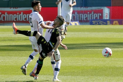 Lucero y Janson luchan por la pelota con un jugador de Aldosivi