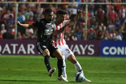 Lucha por la pelota entre Daniel Giraldo y Lucas Esquivel
