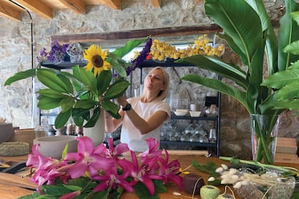 En su taller, entre floreros, esponjas florales y cintas, Luciana arma los ramos para la venta.