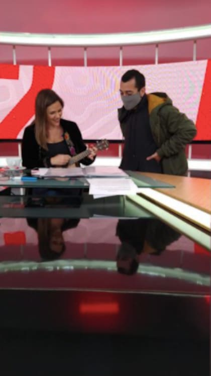Luciana Rubinska sonríe mientras mira el cancionero y es acompañada por el productor de "ESPN F12"