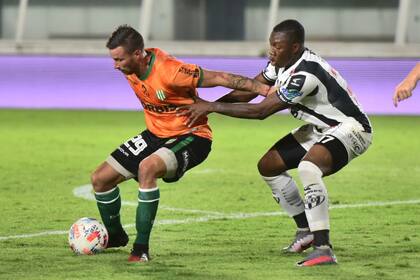 Luciano Pons, de Banfield, cubre la pelota contra la marca de Dixon Rentería; Central Córdoba empató un partido en el que su adversario fue algo superior.