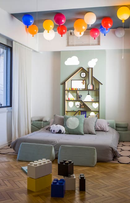Lúdicas y encantadoras, las lámparas ‘Globo’ pueden encenderse individualmente o en conjunto. Estantería-casita (Irizar Kon). Sofá modular para juego en verde (Rincón). Sobre la cama, almohadones (De Levie Casa).