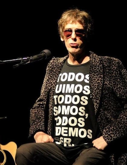 Luis Alberto Spinetta con la remera que lleva el mensaje “Todos fuimos, todos somos, todos podemos ser”, vinculado a la causa de Conduciendo a Conciencia