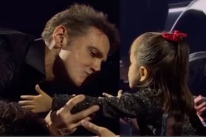 Luis Miguel junto a una niña en un concierto