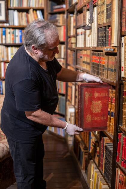 Luis Navas, encargado de la hemeroteca, extrae un antiguo ejemplar de El Quijote.