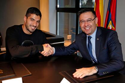 Suárez y el presidente Josep María Bartomeu, en tiempos más amigables entre ambos; "no está claro por qué la directiva tomó esa decisión", manifestó, pero intuye una causa: "Los molestaba que yo me llevara bien con Leo".