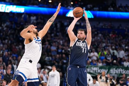 Luka Doncic (77), de los Mavericks de Dallas dispara ante la marca defensiva de Kyle Anderson, de los Timberwolves de Minnesota, durante la segunda mitad del Juego 3 de las finales de la Conferencia Oeste, el domingo 26 de mayo de 2024, en Dallas. (AP Foto/Julio Cortez)