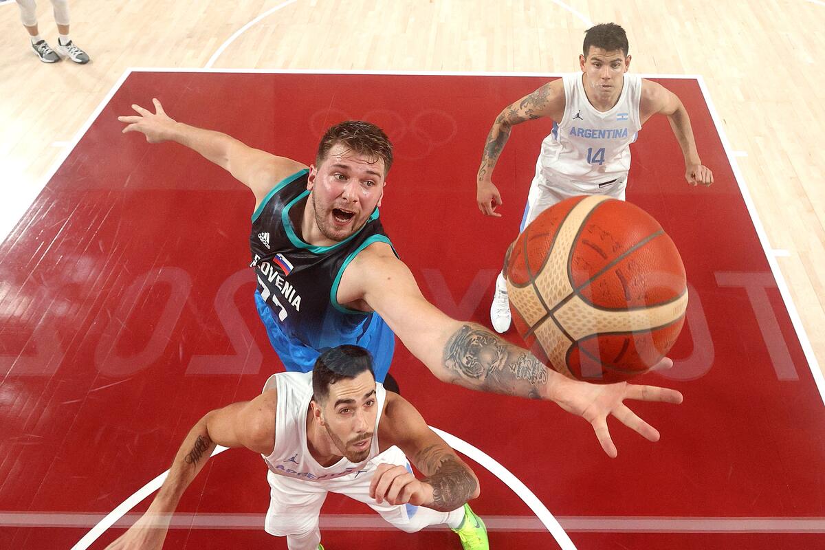 Luka Doncic # 77 del Team Slovenia salta para un rebote contra Luca Vildoza # 17 del Team Argentina durante la primera mitad del tercer día de los Juegos Olímpicos de Tokio 2020 en Saitama Super Arena el 26 de julio de 2021 en Saitama, Japón.