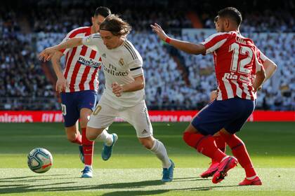 Luka Modric maniobra ante la marca del brasileño Renan Lodi, durante el clásico madrileño que se juega en el estadio Santiago Bernabéu.