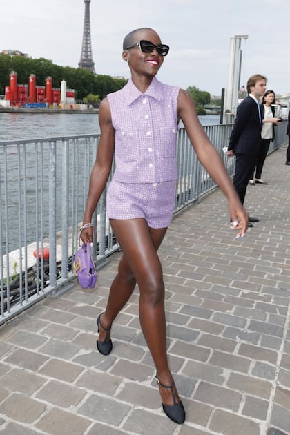 Lupita Nyong’o llega al desfile de Chanel con un conjunto de chaleco y shorts de tweed.