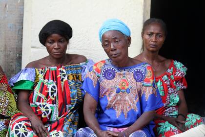 Madeleine Mbalaka, centro, cuyo hijo murió en un intento de fuga en una cárcel de la República Democrática del Congo, con familiares en su casa en la capital, Kinsasa, el 3 de septiembre del 2024. (Foto AP /Benz Bokote)