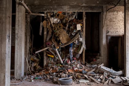 Maderas, cartones, colchones, cables, ropa, y una rueda, adentro del hueco adonde iría un ascensor, basura acumulada durante años