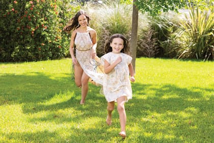 Madre e hija se divierten jugando en el jardín.