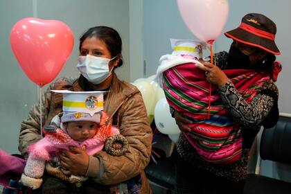Madres cargan a sus bebés mientras asisten a un evento relacionado con el Día Mundial del Niño Prematuro, en el Hospital Del Norte en El Alto, Bolivia, el viernes 19 de noviembre de 2021. (AP Foto/Juan Karita)
