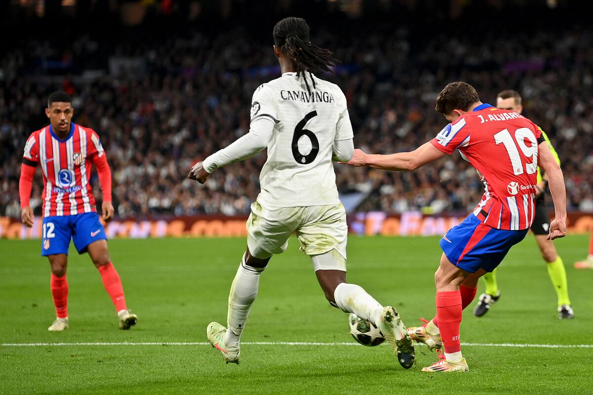 MADRID, SPAIN - MARCH 04: Julian Alvarez of Atletico de Madrid scores his team's first goal whilst under pressure from Eduardo Camavinga of Real Madrid during the UEFA Champions League 2024/25 Round of 16 first leg match between Real Madrid C.F. and Atletico de Madrid at Santiago Bernabeu Stadium on March 04, 2025 in Madrid, Spain. (Photo by Denis Doyle/Getty Images)
