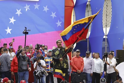 Maduro ondea la bandera venezolana en el acto en Caracas donde se recordó el golpe de 1958 que derrocó al dictadr Marcos Pérez Jiménez, in Caracas, Venezuela, Tuesday, Jan. 23, 2024. (AP Photo/Jesus Vargas)
