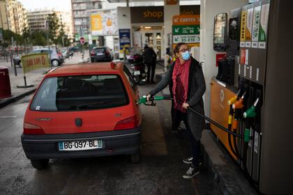 Magalie, que utiliza su automóvil todos los días para ir a trabajar, llena su tanque en una gasolinera de Marsella, Francia, el jueves 21 de octubre de 2021. (AP Foto/Daniel Cole)