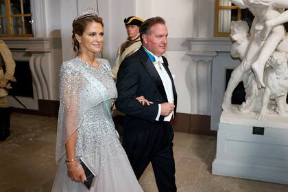 Magdalena -otra de las hijas del Rey- entra del brazo de su marido Christopher O'Neil. La princesa eligió un vestido en gris con bordados de pedrería de la diseñadora británica Jenny Packham.