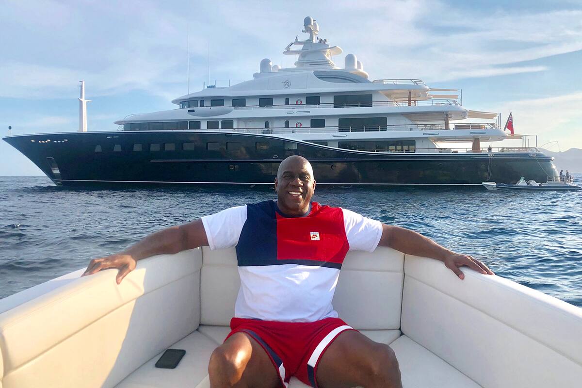 Magic Johnson con el yate Aquila a sus espaldas.