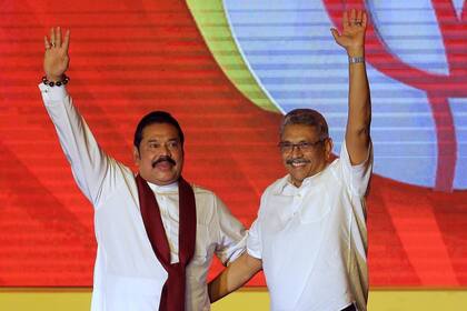 Mahinda Rajapaksa, a la izquierda, y su hermano Gotabaya Rajapaksa saludan a sus seguidores durante una convención del partido celebrada para anunciar la candidatura presidencial de Gotabaya en Colombo, Sri Lanka, el 11 de agosto de 2019