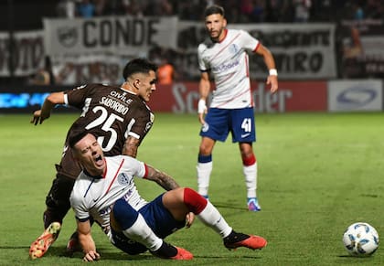 Malcom Braida cae dolorido, ante la marca de Juan Saborido; no hubo mala intención en el partido, pero el segundo tiempo fue un carrusel de fragor y asperezas.