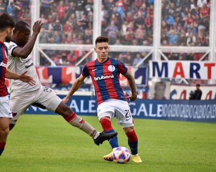 Malcom Braida, carrilero por la izquierda de San Lorenzo, es marcado por Baldomero Perlaza, mediocampista de Colón