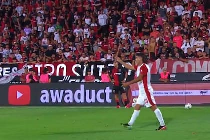 Malcorra le muestra al árbitro Zamora uno de los objetos contundentes que le arrojaron en el Coloso