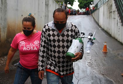 Dos ciudadanos en Manaos transportan un cilindro de oxígeno